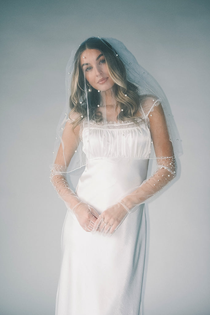 a white satin midi dress with lace detailing + a fitted silhouette. the perfect short sleeve occasion dress for weddings, bridal showers, + dinner parties.