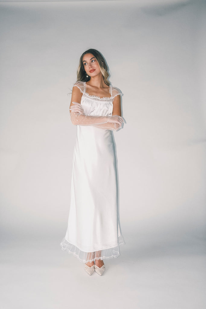 a white satin midi dress with lace detailing + a fitted silhouette. the perfect short sleeve occasion dress for weddings, bridal showers, + dinner parties.