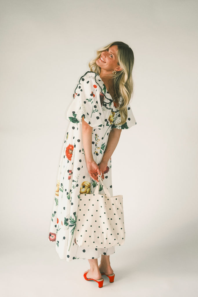 a polka dot puff sleeve dress with floral print details. the perfect polka dot midi dress for baby showers, family pictures, + special occasions.