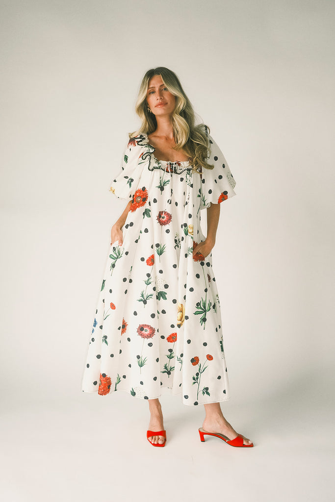 a polka dot puff sleeve dress with floral print details. the perfect polka dot midi dress for baby showers, family pictures, + special occasions.