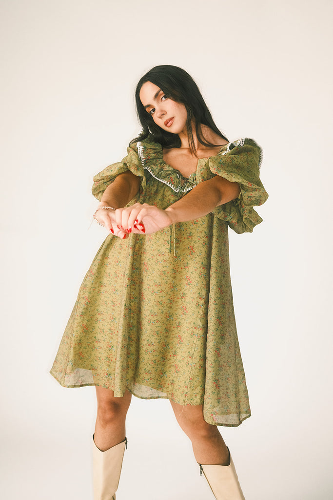 a green floral puff sleeve mini dress with a ruffle neckline. the perfect vintage-inspired dress for baby showers, family pictures, + special occasions.