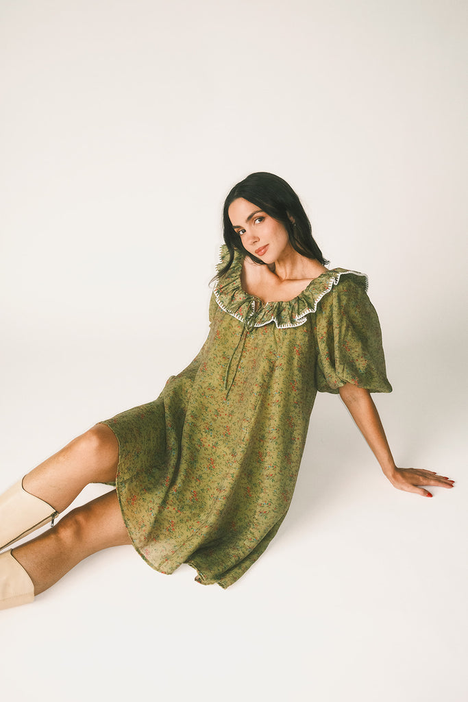 a green floral puff sleeve mini dress with a ruffle neckline. the perfect vintage-inspired dress for baby showers, family pictures, + special occasions.