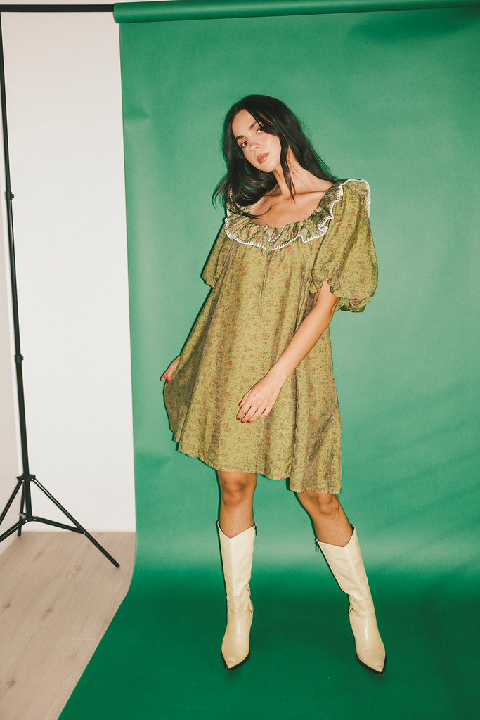a green floral puff sleeve mini dress with a ruffle neckline. the perfect vintage-inspired dress for baby showers, family pictures, + special occasions.