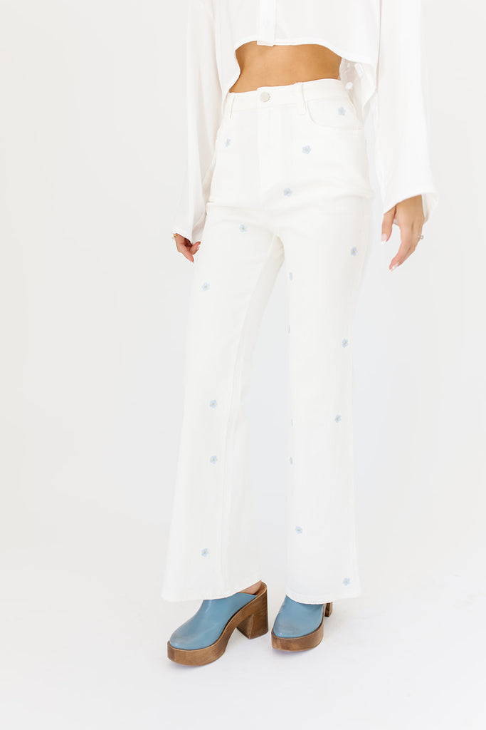white denim with embroidered daisies, slight flare, one button zipper fly, pockets, and belt loops.