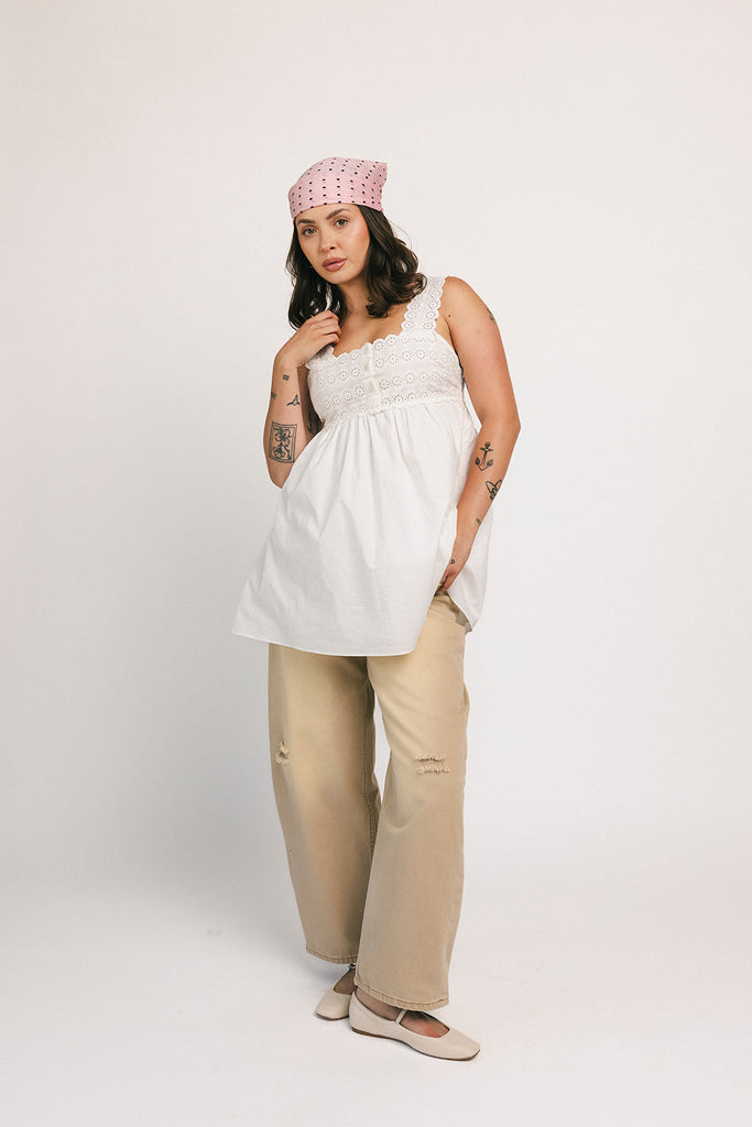 a white tank with a babydoll style silhouette + eyelet details. pair it with the matching white shorts to create the perfect two piece set for brunch dates, vacations, + everyday wear. 