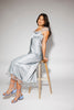 a light blue silk midi dress with lace detailing + a fitted silhouette. the perfect short sleeve occasion dress for weddings, bridal showers, + dinner parties.
