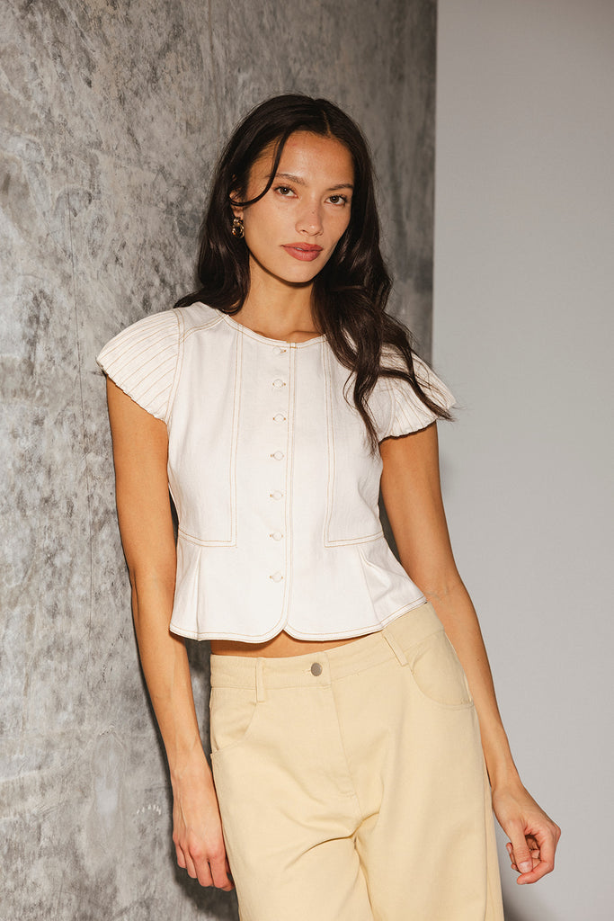 a white denim short sleeve top with a fitted silhouette + a peplum hemline. the perfect denim top to dress up or down for any outfit idea.
