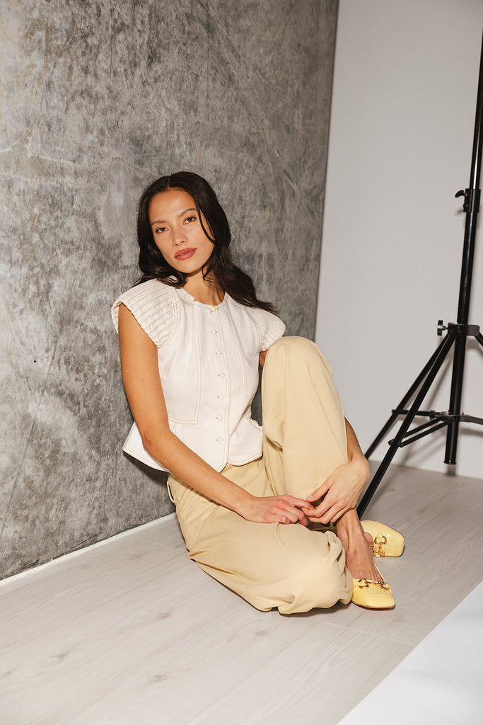 a white denim short sleeve top with a fitted silhouette + a peplum hemline. the perfect denim top to dress up or down for any outfit idea.
