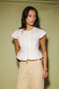 a white denim short sleeve top with a fitted silhouette + a peplum hemline. the perfect denim top to dress up or down for any outfit idea.
