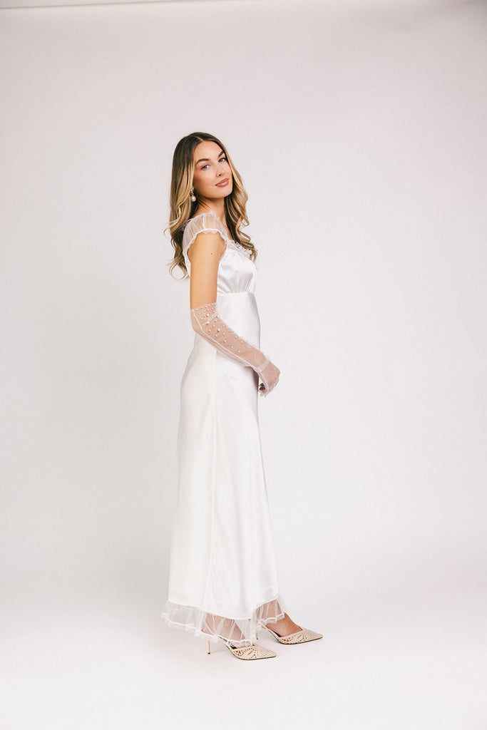 a white satin midi dress with lace detailing + a fitted silhouette. the perfect short sleeve occasion dress for weddings, bridal showers, + dinner parties.
