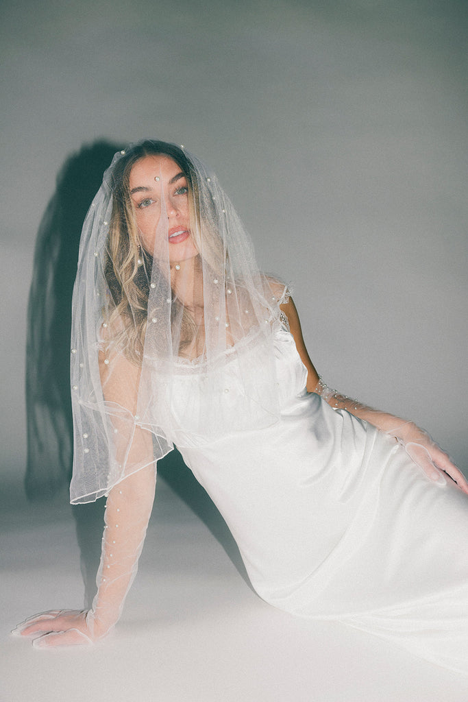 a white satin midi dress with lace detailing + a fitted silhouette. the perfect short sleeve occasion dress for weddings, bridal showers, + dinner parties.
