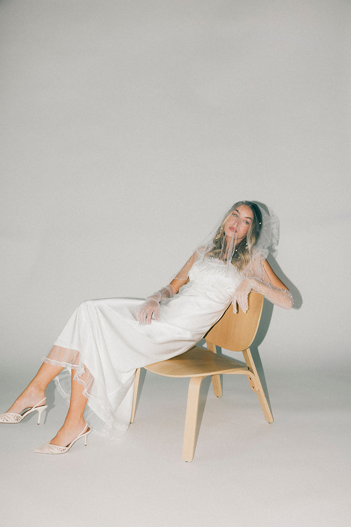 a white satin midi dress with lace detailing + a fitted silhouette. the perfect short sleeve occasion dress for weddings, bridal showers, + dinner parties.
