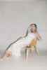 a white satin midi dress with lace detailing + a fitted silhouette. the perfect short sleeve occasion dress for weddings, bridal showers, + dinner parties.
