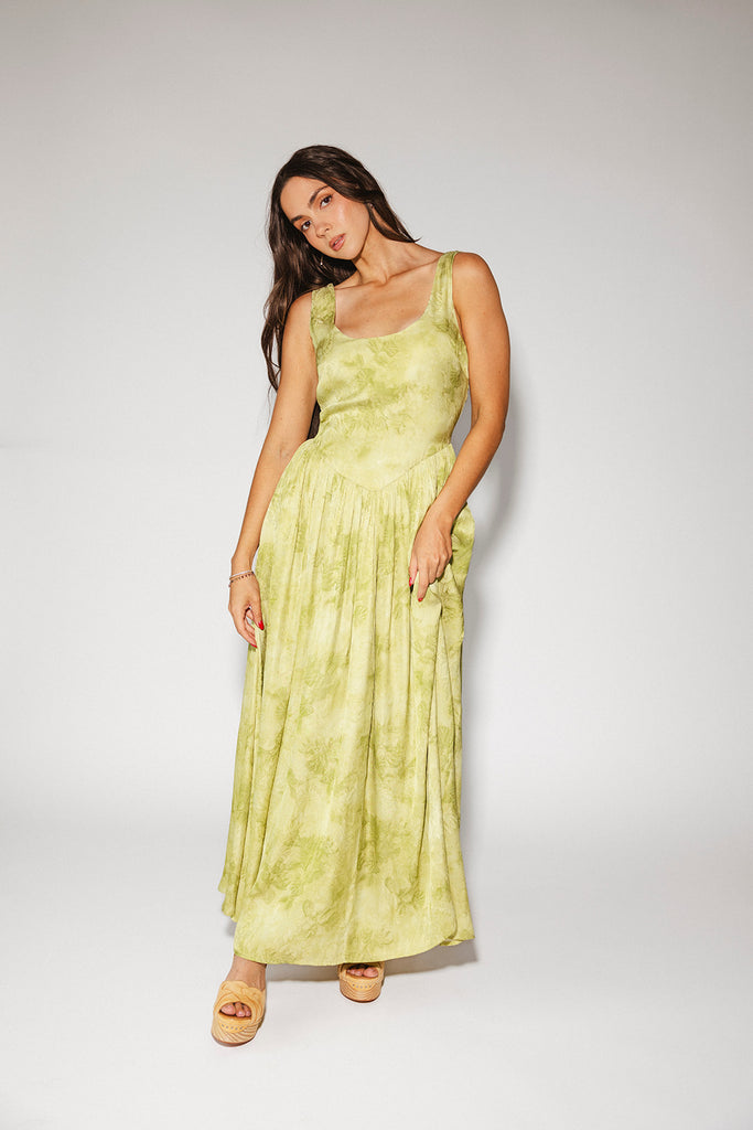 a flowy v-waist green dress with a sleek scoop neckline + subtle floral print. the perfect vintage-inspired maxi dress for weddings, bridal showers, + garden parties.
