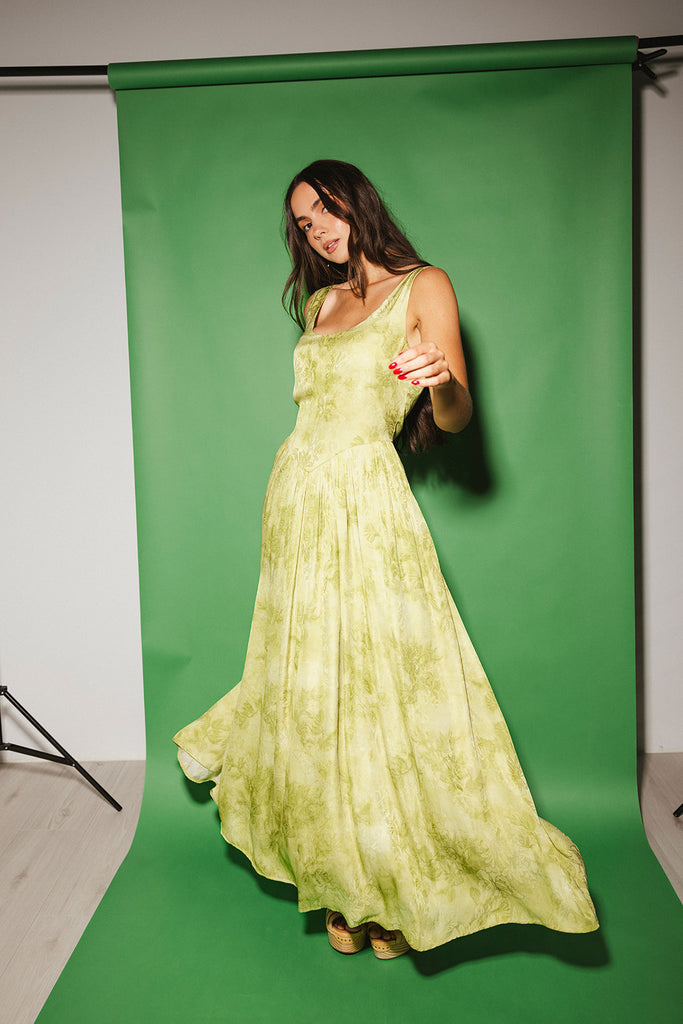 a flowy v-waist green dress with a sleek scoop neckline + subtle floral print. the perfect vintage-inspired maxi dress for weddings, bridal showers, + garden parties.
