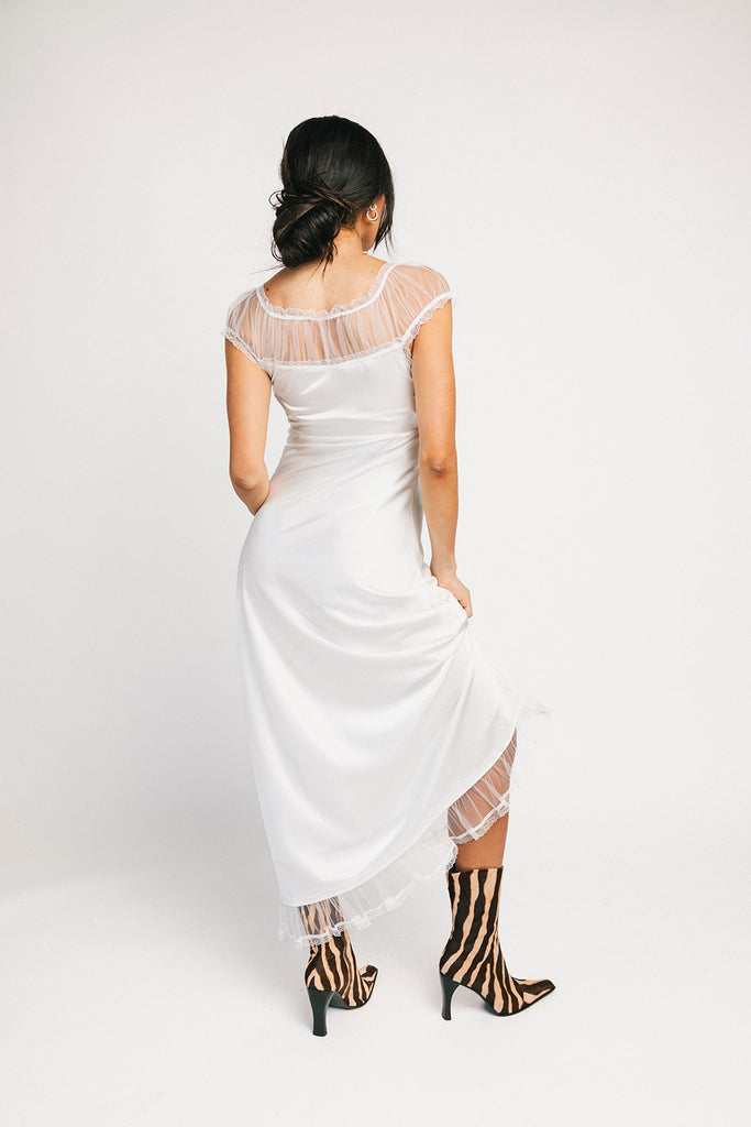 a white satin midi dress with lace detailing + a fitted silhouette. the perfect short sleeve occasion dress for weddings, bridal showers, + dinner parties.
