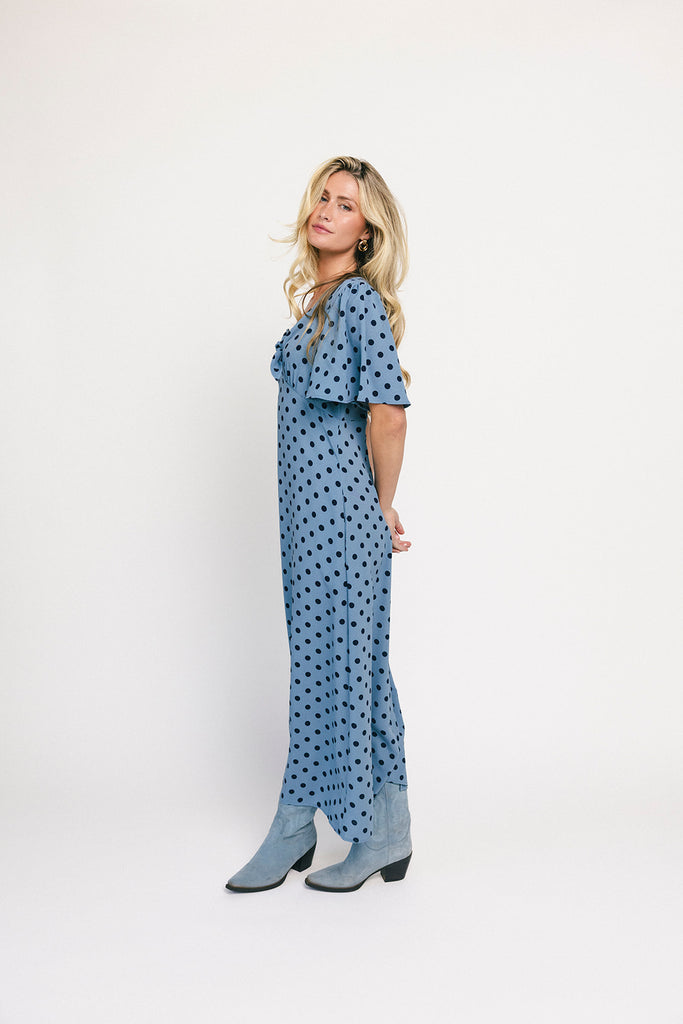 a blue polka dot maxi dress with flutter sleeves + a front tie detail. the perfect short sleeve polka dot dress for brunch dates, baby showers, + semi-formal occasions.
