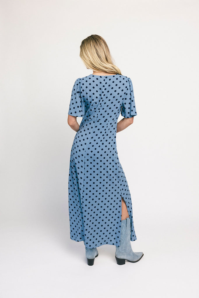 a blue polka dot maxi dress with flutter sleeves + a front tie detail. the perfect short sleeve polka dot dress for brunch dates, baby showers, + semi-formal occasions.
