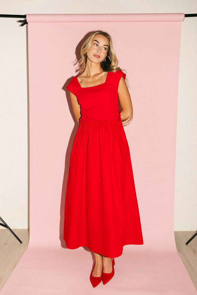 zoco afterglow dress: red short sleeve midi dress with a square neckline and side ties. perfect for date nights, weddings, and family pictures.
