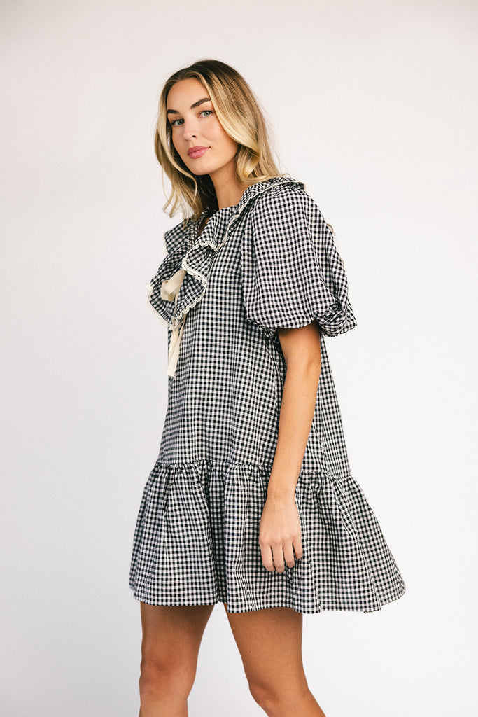 vintage inspired puff sleeve mini dress with a lace trim collar. the perfect black and white gingham mini dress for baby showers, bridal showers, and semi-formal occasions.

