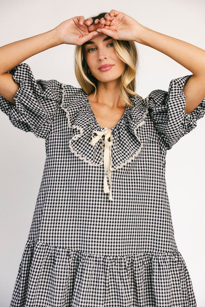 vintage inspired puff sleeve mini dress with a lace trim collar. the perfect black and white gingham mini dress for baby showers, bridal showers, and semi-formal occasions.
