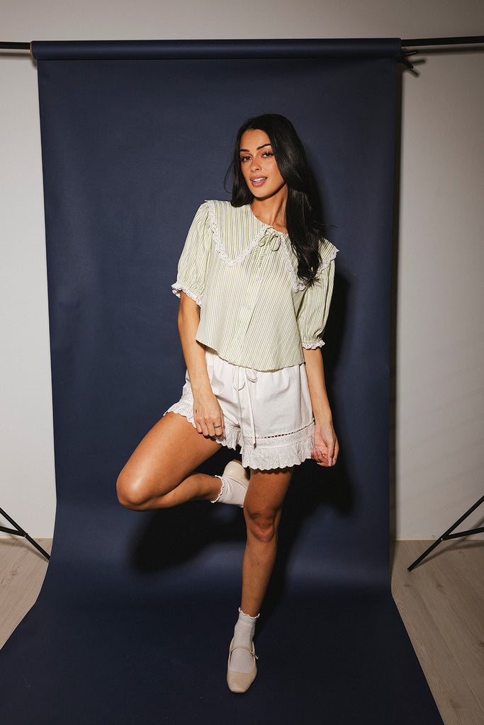 a vintage-inspired puff sleeve top with a pastel green pinstripe pattern + an oversized lace trim collar. the perfect elevated button up top for the office, dressy date nights, + everyday wear.
