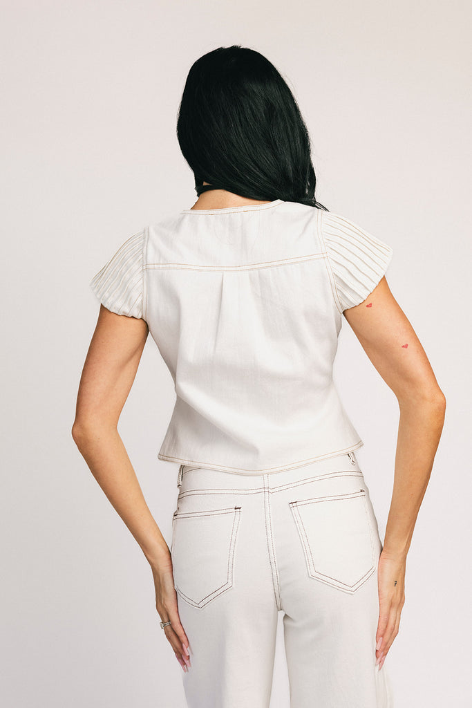 a white denim short sleeve top with a fitted silhouette + a peplum hemline. the perfect denim top to dress up or down for any outfit idea.
