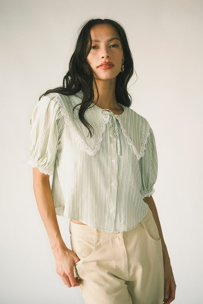 a vintage-inspired puff sleeve top with a pastel green pinstripe pattern + an oversized lace trim collar. the perfect elevated button up top for the office, dressy date nights, + everyday wear.
