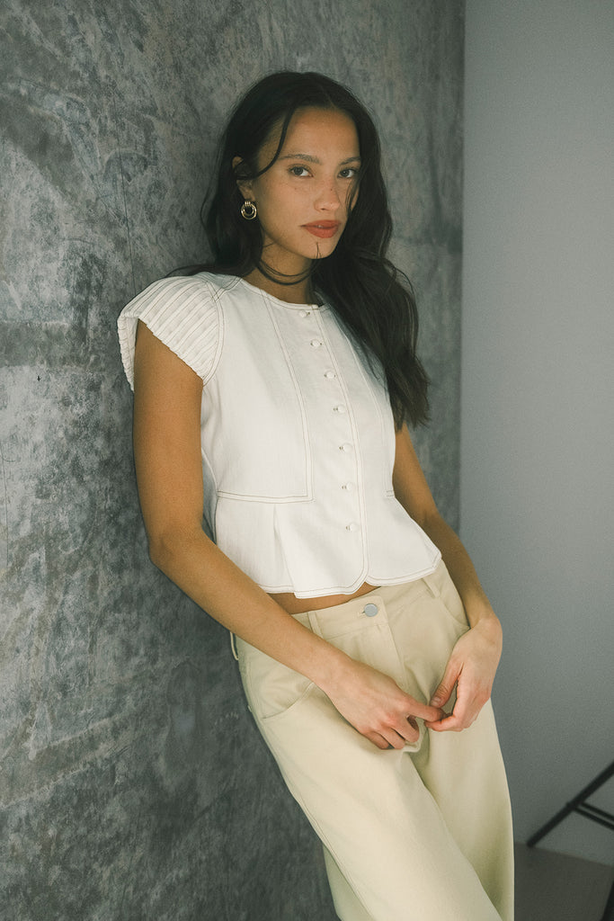 a white denim short sleeve top with a fitted silhouette + a peplum hemline. the perfect denim top to dress up or down for any outfit idea.
