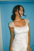 a white satin midi dress with lace detailing + a fitted silhouette. the perfect short sleeve occasion dress for weddings, bridal showers, + dinner parties.
