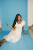 a white vintage-inspired midi dress with a lace ruffle neckline + bow detail. the perfect white dress for bridal showers, rehearsal dinners, + any special occasion.
