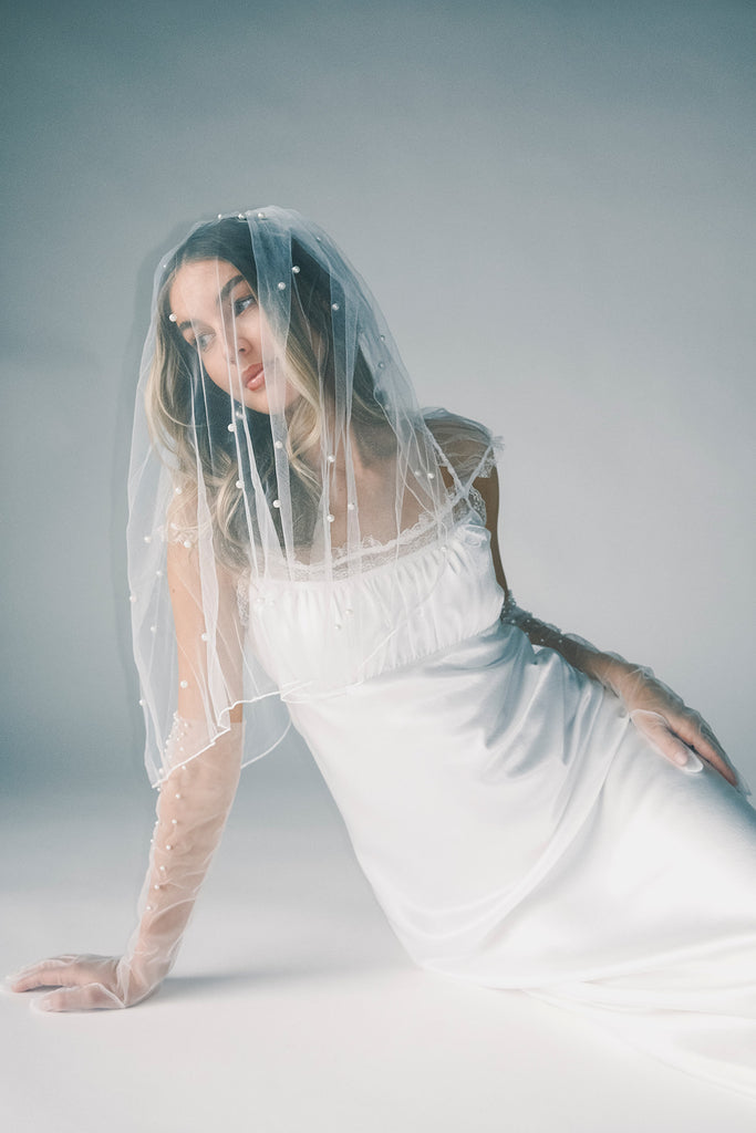 a white satin midi dress with lace detailing + a fitted silhouette. the perfect short sleeve occasion dress for weddings, bridal showers, + dinner parties.
