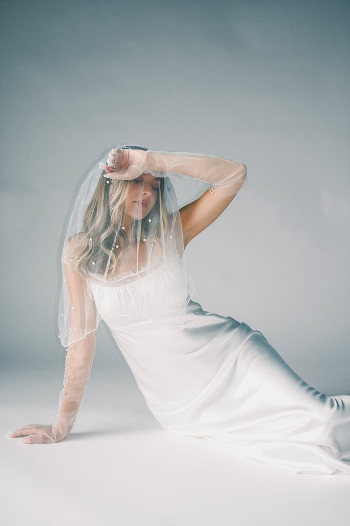 a white satin midi dress with lace detailing + a fitted silhouette. the perfect short sleeve occasion dress for weddings, bridal showers, + dinner parties.
