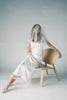a white satin midi dress with lace detailing + a fitted silhouette. the perfect short sleeve occasion dress for weddings, bridal showers, + dinner parties.
