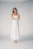 a white satin midi dress with lace detailing + a fitted silhouette. the perfect short sleeve occasion dress for weddings, bridal showers, + dinner parties.
