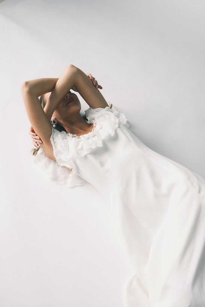 a white vintage-inspired midi dress with a lace ruffle neckline + bow detail. the perfect white dress for bridal showers, rehearsal dinners, + any special occasion.
