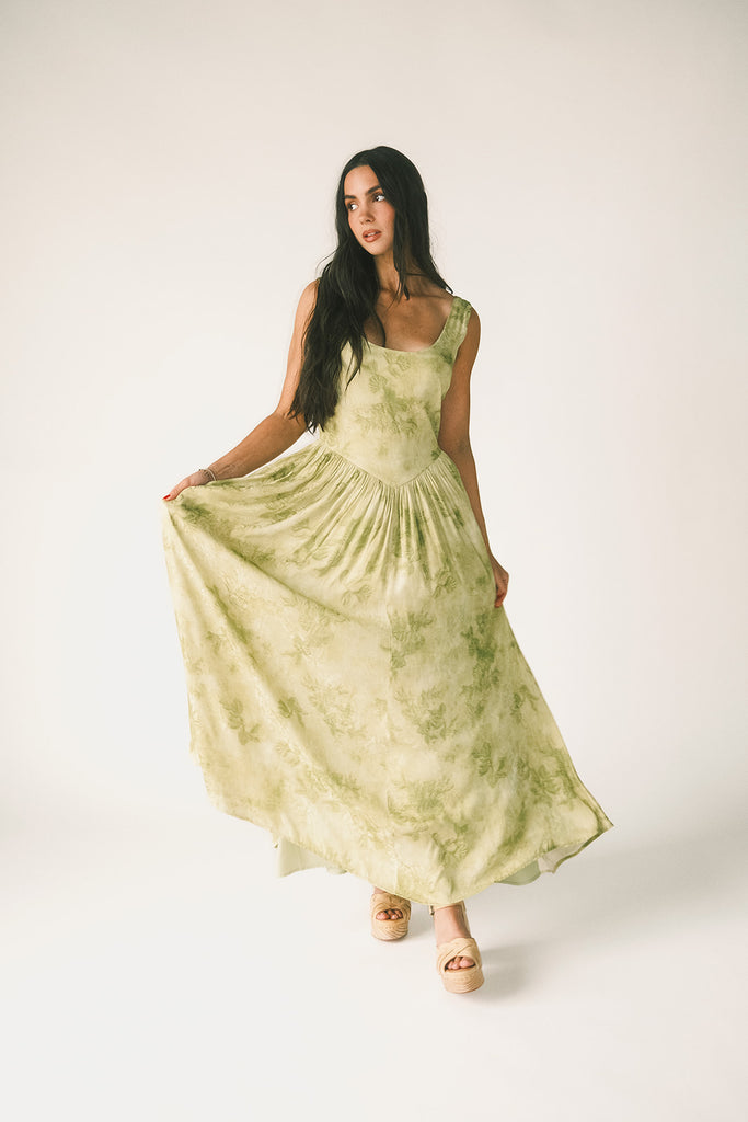a flowy v-waist green dress with a sleek scoop neckline + subtle floral print. the perfect vintage-inspired maxi dress for weddings, bridal showers, + garden parties.

