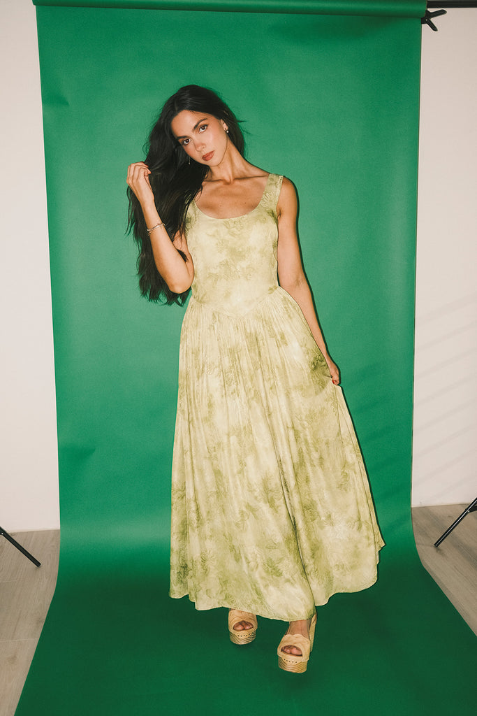 a flowy v-waist green dress with a sleek scoop neckline + subtle floral print. the perfect vintage-inspired maxi dress for weddings, bridal showers, + garden parties.
